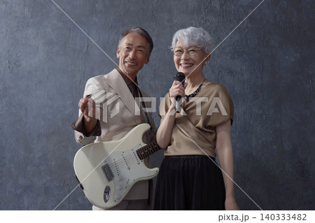 シニアのミュージシャン 男性のギタリストと女性のボーカル 黒背景 シニアのミュージシャン 男性のギタリストと女性のボーカル 黒背景 140333482