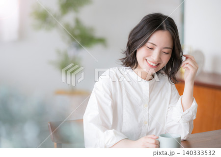 自宅でリラックスしながら笑顔を見せる若い女性や主婦のライフスタイル　くつろぐリラックスで微笑む 140333532