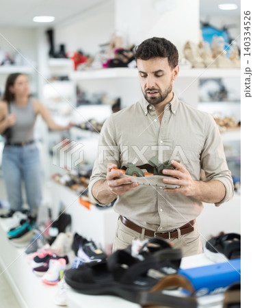 Man spends time in store and pick up sandals Man spends time in store and pick up sandals 140334526