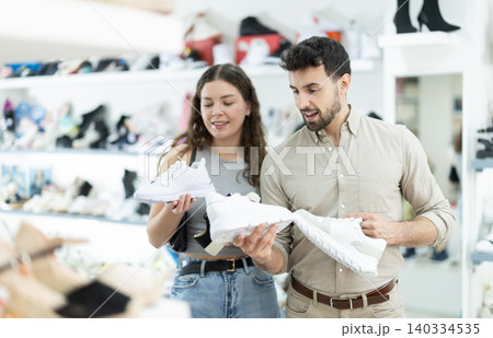is interested in choosing sneakers in the store is interested in choosing sneakers in the store 140334535