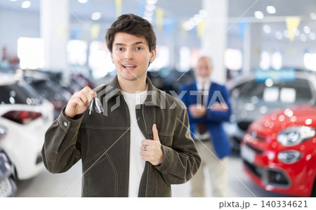 Guy is joyful to buy a car, he keeps the keys in his hands Guy is joyful to buy a car, he keeps the keys in his hands 140334621