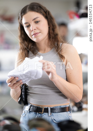 Young woman choosing sneakers in shoe store 140334713