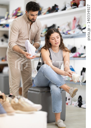 Young woman choosing sandals at footwear store Young woman choosing sandals at footwear store 140334927