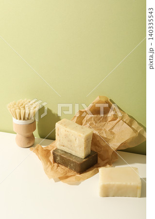Natural soap bars stacked with a brush nearby on paper Natural soap bars stacked with a brush nearby on paper 140335543