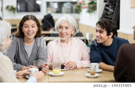 older generation of the family communicates with their grandchildren in a cafe older generation of the family communicates with their grandchildren in a cafe 140335905