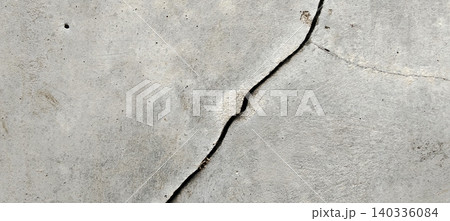 Diagonal cracks in an old concrete wall with an abstract rough texture 140336084