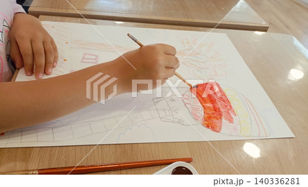 Child Painting with Watercolors - Kids Art Activity Drawing Colorful Picture on Paper at Wooden Table 140336281