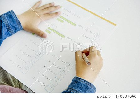 プリントで引き算の勉強をする子供の手元 鉛筆を持って数字を書き込む小学生の学習イメージ プリントで引き算の勉強をする子供の手元 鉛筆を持って数字を書き込む小学生の学習イメージ 140337060