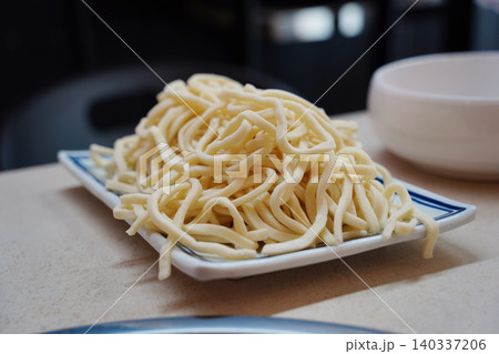 Handmade Korean knife-cut noodles before cooking, raw Kalguksu Handmade Korean knife-cut noodles before cooking, raw Kalguksu 140337206