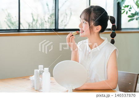 鏡を見ながらリップ,口紅,メイクする子供,女の子,小学生,中学生 鏡を見ながらリップ,口紅,メイクする子供,女の子,小学生,中学生 140337870