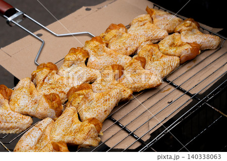 BBQ picnic time Roasted chicken legs and wings on grill. Grilling meat on outdoor grill grid tasty barbeque chicken steak with smoke flames juicy meat in the backyard 140338063