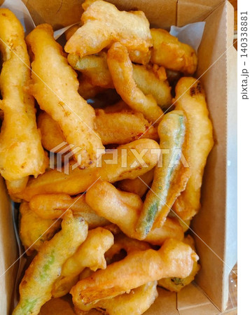 Golden brown deep-fried crispy vegetables tempura served in a brown paper box packaging. Golden brown deep-fried crispy vegetables tempura served in a brown paper box packaging. 140338881