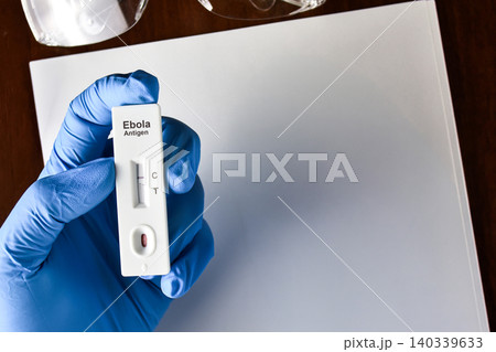 Gloved hand holding a negative Ebola antigen rapid test kit cassette Gloved hand holding a negative Ebola antigen rapid test kit cassette 140339633