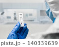 A gloved scientist holds a positive Ebola antigen rapid test cassette 140339639