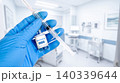 Gloved hand holding a hantavirus vaccine vial and medical syringe 140339644