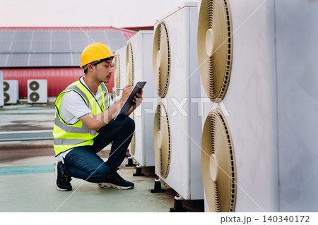Technician inspects cooling units with tablet Technician inspects cooling units with tablet 140340172