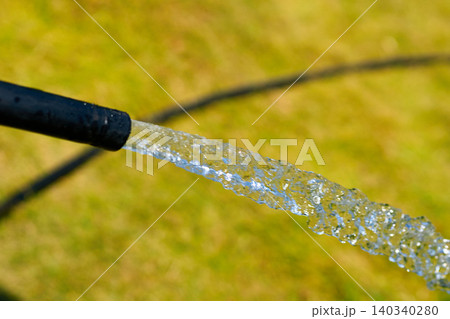 Hot summer.Hose draining water for watering and washing 140340280