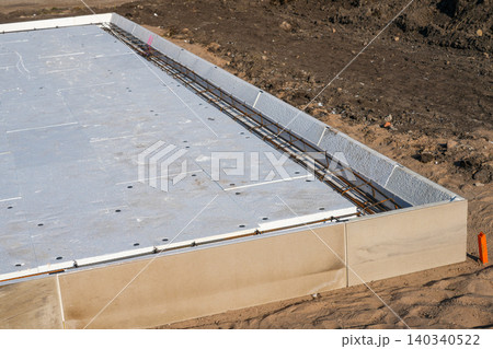 Insulated foundation edge beam with steel reinforcement prepared for concrete slab construction work 140340522