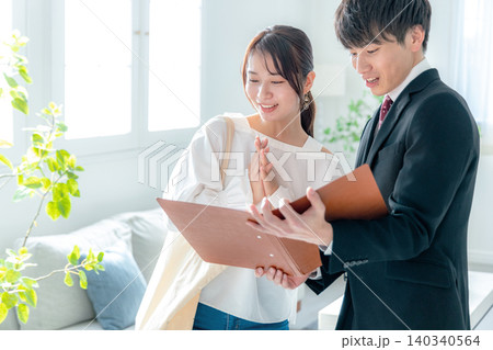 一人暮らしをする女性の家の内見をビジネスマンとするシーン 一人暮らしをする女性の家の内見をビジネスマンとするシーン 140340564