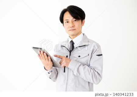 タブレットを持つグレーの作業着のミドル男性ビジネスマン白バック 140341233