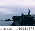Lone fisherman casting a line beside a coastal sculpture on rocky lava shoreline, Sicily, Italy 140341873
