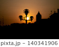 Ornate street lamp silhouette against golden sunset sky in Caltagirone, Sicily 140341906