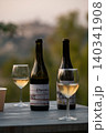 Sicilian natural wine bottles and glasses at golden hour outdoor table 140341908
