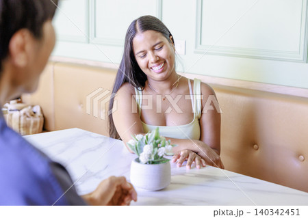 カフェで過ごすデート中の若い女性のリラックスした時間 カフェで過ごすデート中の若い女性のリラックスした時間 140342451