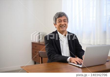 ノートパソコンで作業をするジャケットを着た60代男性 ノートパソコンで作業をするジャケットを着た60代男性 140342706