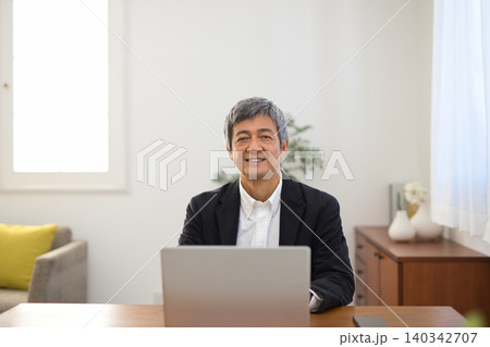 ノートパソコンで作業をするジャケットを着た60代男性 ノートパソコンで作業をするジャケットを着た60代男性 140342707