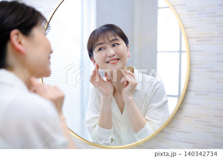 鏡を見て微笑むシニアの女性 鏡を見て微笑むシニアの女性 140342734