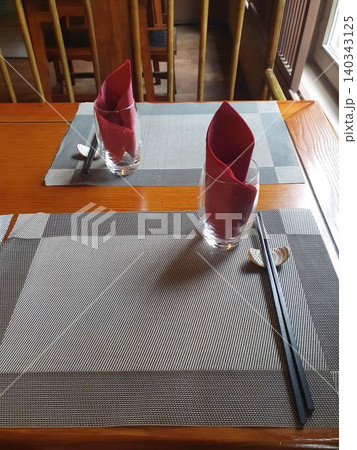 Chinese restaurant empty dinner placement with napkins and chopsticks Chinese restaurant empty dinner placement with napkins and chopsticks 140343125