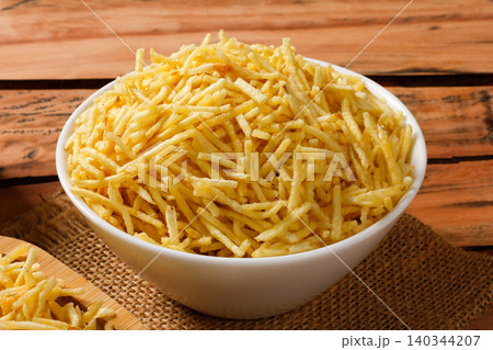 Portion of golden potato sticks inside a white ceramic bowl with burlap fabric at the bottom Portion of golden potato sticks inside a white ceramic bowl with burlap fabric at the bottom 140344207