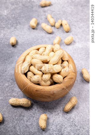 Peanuts in wooden bowl, healthy snack concept Peanuts in wooden bowl, healthy snack concept 140344419