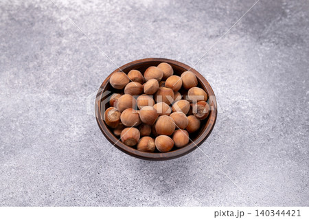 Hazelnuts in wooden bowl on rustic background 140344421