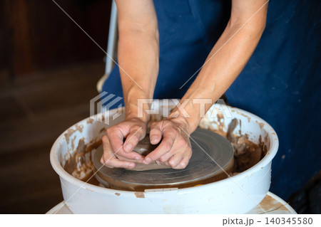 Crafting unique pottery pieces at a local studio during a clay workshop in the afternoon sun 140345580