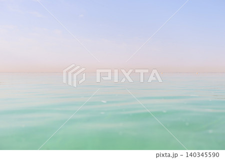 Tranquil waters of a calm sea under a bright sky at midday in a serene environment Tranquil waters of a calm sea under a bright sky at midday in a serene environment 140345590