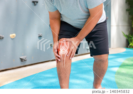 Close up of unrecognizable man suffering from knee joint pain with glowing bone anatomy graphic overlay after rock climbing exercise. Sports injury and medical healthcare concept. Close up of unrecognizable man suffering from knee joint pain with glowing bone anatomy graphic overlay after rock climbing exercise. Sports injury and medical healthcare concept. 140345832