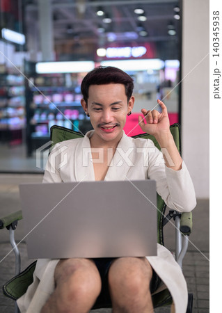 Thai Non-Binary Gay Man Video Calling on Laptop Outdoors Thai Non-Binary Gay Man Video Calling on Laptop Outdoors 140345938