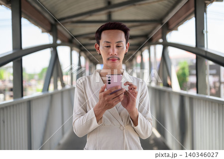 Thai Non-Binary Gay Man Using Smartphone on Bridge Overpass Thai Non-Binary Gay Man Using Smartphone on Bridge Overpass 140346027