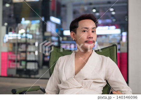 Thai Non-Binary Gay Man Sitting in Folding Chair Outdoors 140346096