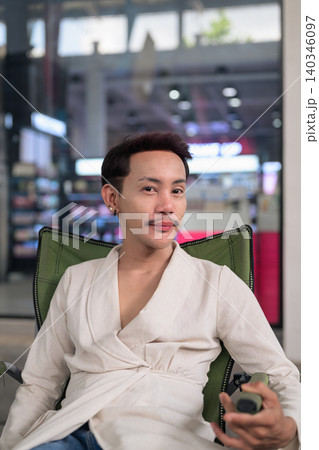 Thai Non-Binary Gay Man Sitting in Folding Chair Vertical Portrait 140346097