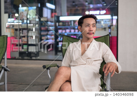 Thai Non-Binary Gay Man Thinking in Folding Chair Outdoors Thai Non-Binary Gay Man Thinking in Folding Chair Outdoors 140346098