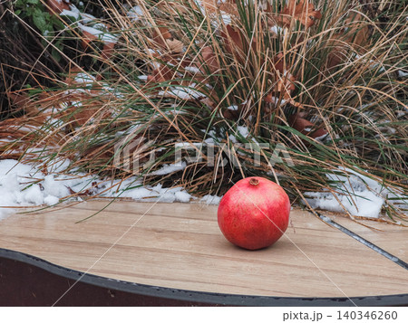 Ripe pomegranate fruit on wooden surface during cold winter Ripe pomegranate fruit on wooden surface during cold winter 140346260