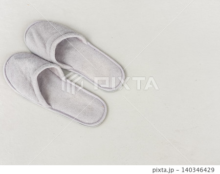 Pair of soft gray slippers on painted floor Pair of soft gray slippers on painted floor 140346429