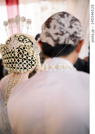 An elegant Javanese bridal couple with traditional jasmine flower hair ornaments. An elegant Javanese bridal couple with traditional jasmine flower hair ornaments. 140346528