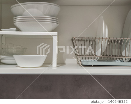 Organizing kitchen dishes in modern cabinet Organizing kitchen dishes in modern cabinet 140346532