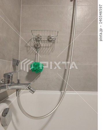 Modern bathroom showing bathtub shower faucet and bath sponge 140346597
