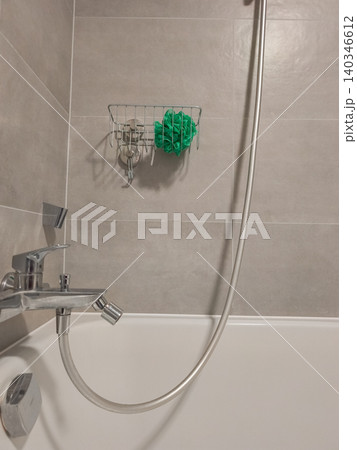 Bathtub shower with metal basket and green sponge Bathtub shower with metal basket and green sponge 140346612