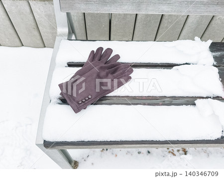 Lost gloves resting on a snow covered park bench Lost gloves resting on a snow covered park bench 140346709